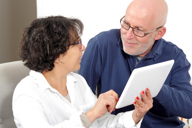 Portrait of a happy senior couple using tablet digital