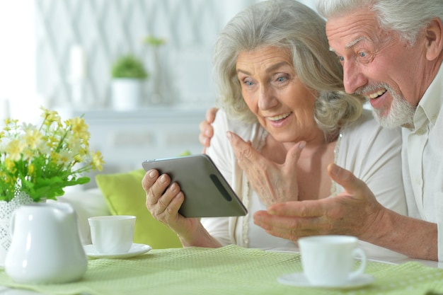 Portrait of happy senior couple using tablet