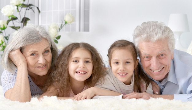 Portrait of a happy senior couple with grandchildren  at home