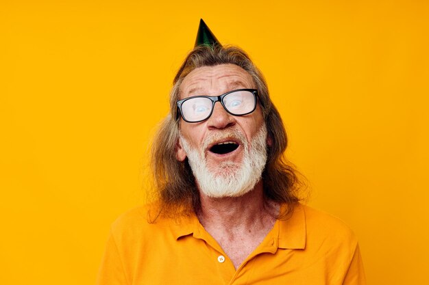 Ritratto di felice uomo anziano divertente compleanno cappuccio sullo sfondo testa isolato