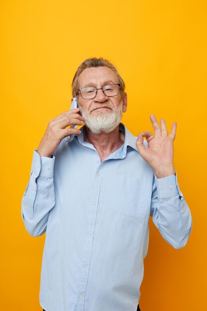 Portrait of happy senior man gray beard with glasses talking on the phone cropped view