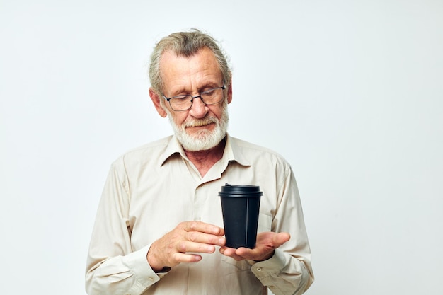 Portrait of happy senior man in a shirt and glasses a black glass cropped view