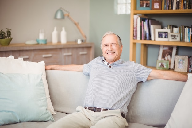 Portrait of happy senior man sitting at home