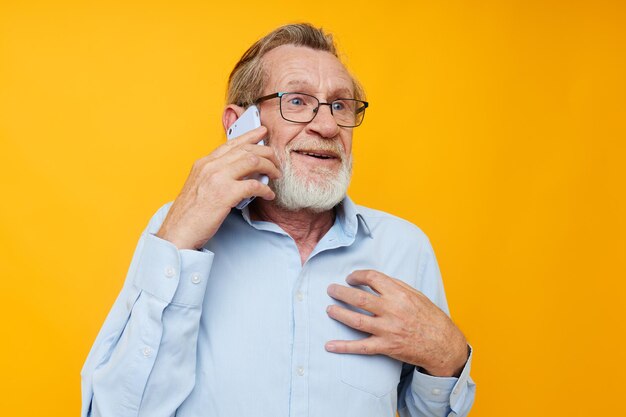 Portrait of happy senior man talking on the phone posing closeup isolated background