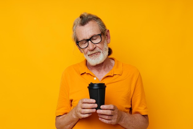 Portrait of happy senior man with black disposable cup isolated background