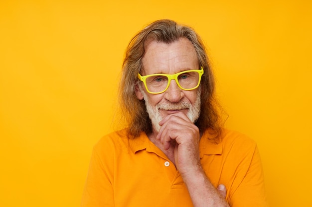 Portrait of happy senior man in yellow glasses with a gray\
beard emotions cropped view