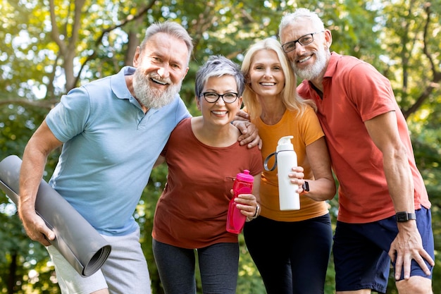 Portrait of happy senior people posing together outdoors after fitness training