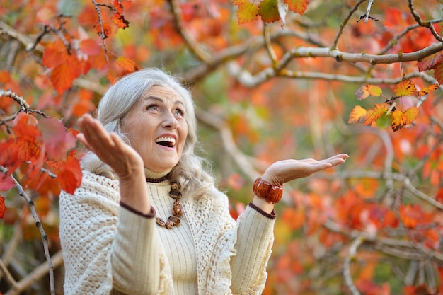 Foto ritratto di una donna anziana felice nel parco d'autunno