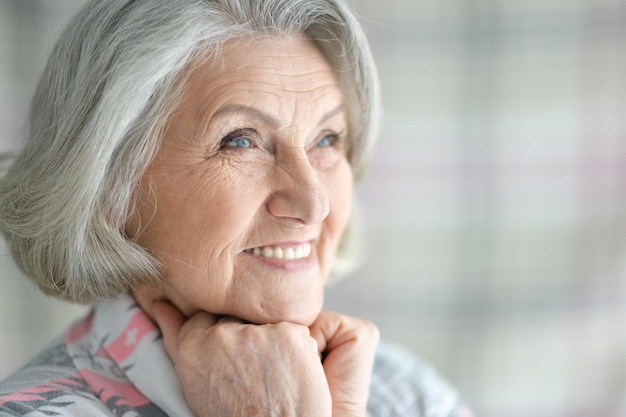 Портрет счастливой старшей женщины, позирующей дома