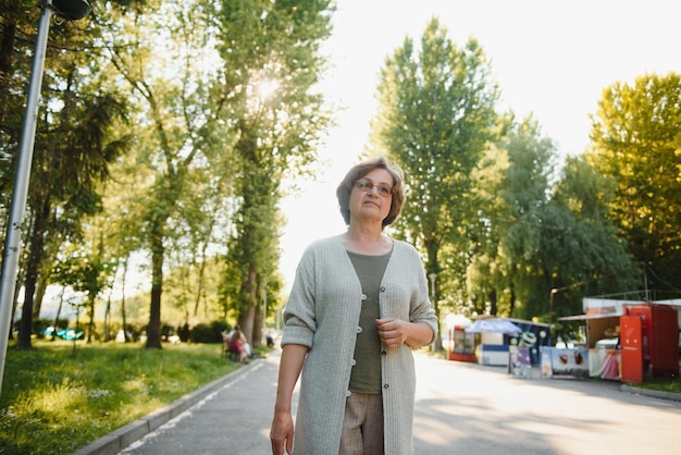 Портрет счастливой пожилой женщины в летнем парке