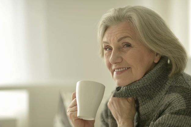 Ritratto di una donna anziana felice con tazza