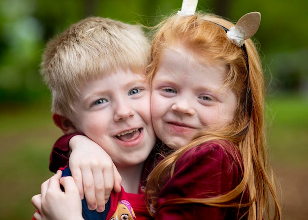 Photo portrait of happy siblings embracing at park