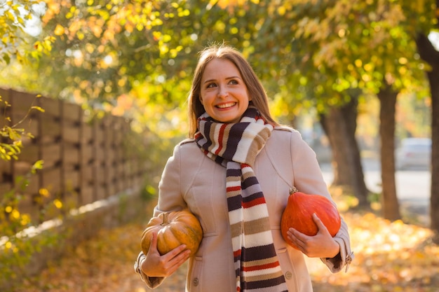 Photo portrait of happy smile woman with pumpkins in hand