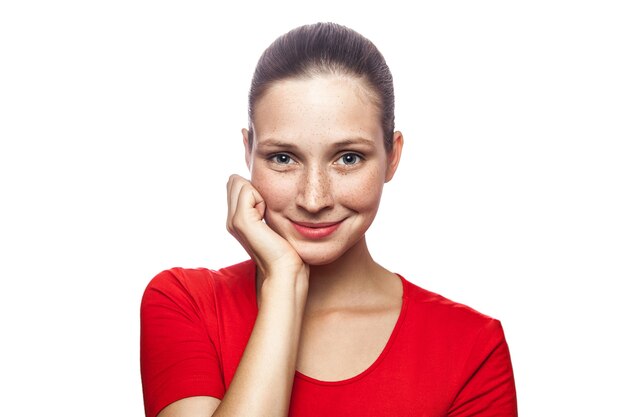 Portrait of happy smiley woman in red tshirt with freckles looking at camera