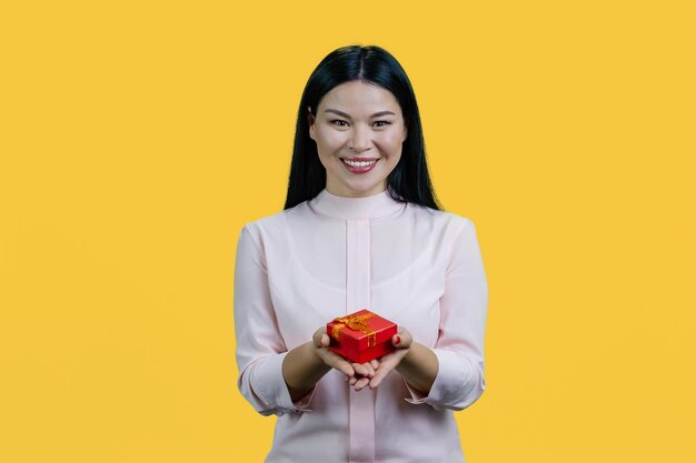 Portrait of happy smiling asian woman holding gift box in both hands