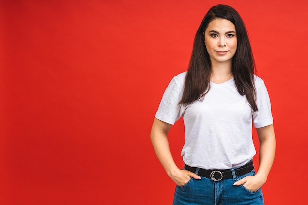 Portrait of happy smiling brunette business girl woman in casual isolated over red background