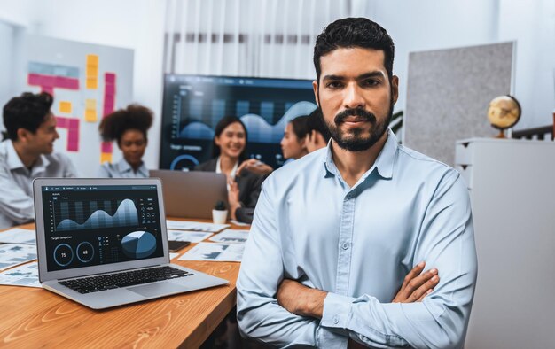 Portrait of happy and smiling businessman with group of coworkers on meeting with screen display business dashboard in background Confident office worker at team meeting Concord