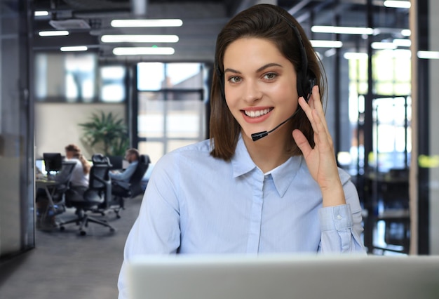 Portrait of happy smiling cheerful support phone operator in headset at office