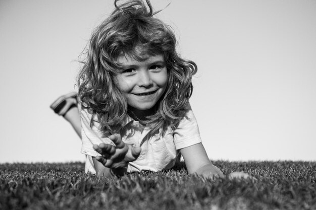 잔디 필드에서 노는 행복한 웃는 아이 소년의 초상화 웃는 아이 표정 표정