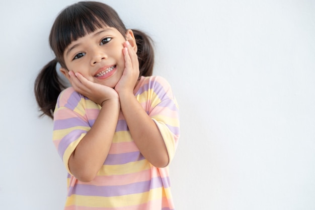 白い背景で隔離幸せな笑顔の子供の女の子の肖像画