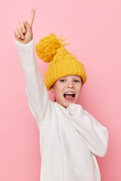 Portrait of happy smiling child girl in a sweater and a hat childhood unaltered