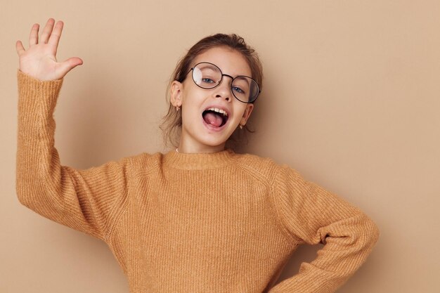 Portrait of happy smiling child girl with glasses emotions gesture hands lifestyle unaltered