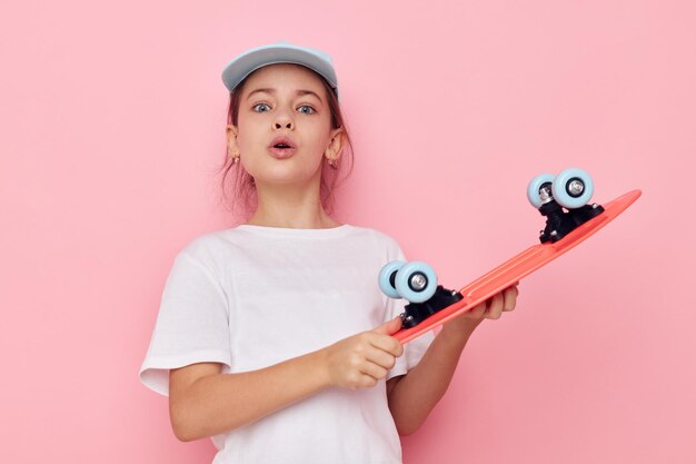 Photo portrait of happy smiling child girl with a skateboard in hand childhood unaltered