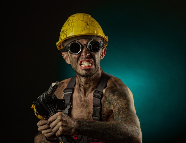 Portrait of happy smiling coal miner with his arms crossed against a dark background