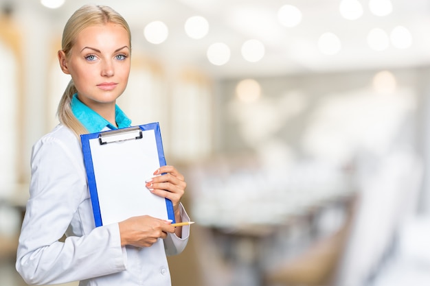 Portrait of happy smiling confident glad beautiful with blonde hair female family doctor wearing white coat