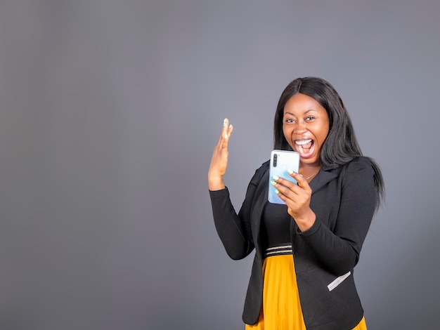 Portrait of  happy smiling elegant lady boss in a suit reading a positive message on her smartphone