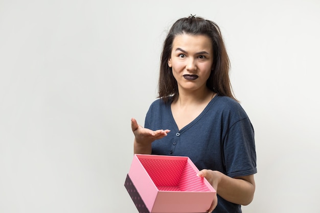 Portrait of a happy smiling girl opening a gift box isolated over white background