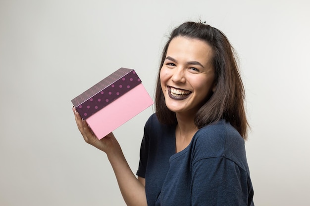 흰색 배경 위에 격리된 선물 상자를 여는 행복한 웃는 소녀의 초상화