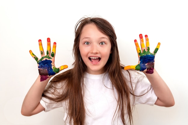 Portrait of a happy and smiling girl with multi-colored palms. The girl looks surprised and enthusiastic, her eyes wide open.