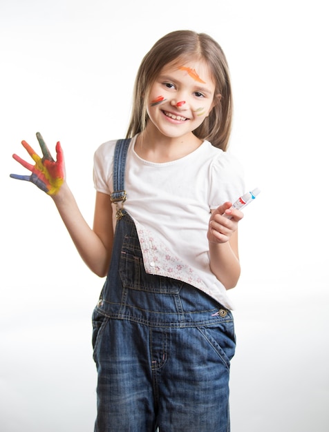 Ritratto di ragazza sorridente felice con le mani dipinte e il viso su sfondo bianco