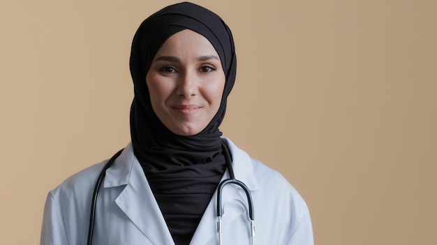 肖像画幸せな笑みを浮かべてイスラム教徒のアラブ女性イスラム医師医師ヒジャーブ着用白い医療コート