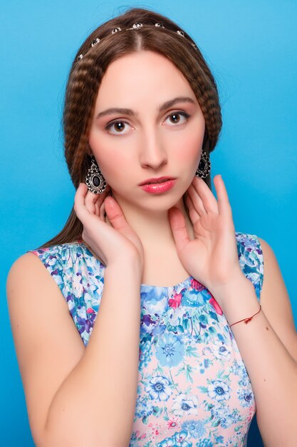 Portrait of happy smiling young beautiful woman in blue casual clothing, over blue wall