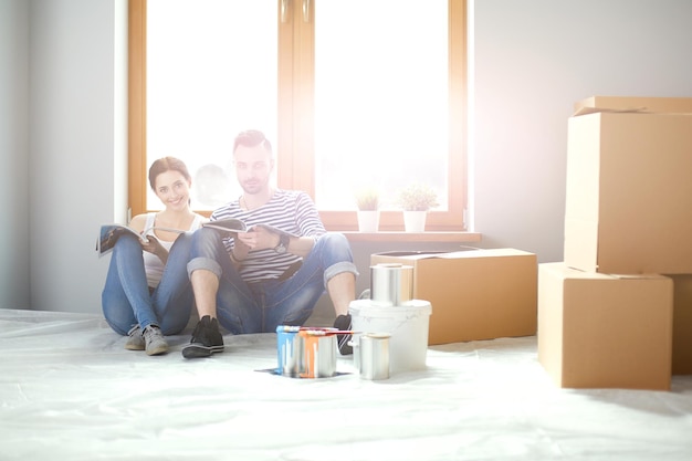 Portrait happy smiling young couple painting interior wall of new house Young couple