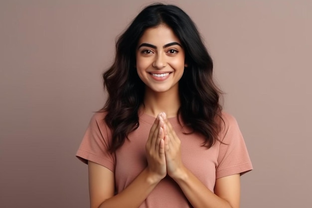 portrait of happy smiling young lady of indian ethnicity looking at camera holding fingers joined in