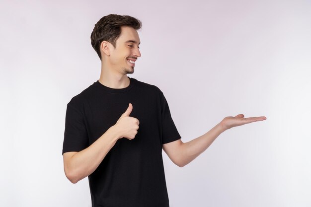 Portrait of happy smiling young man presenting and showing your text or product isolated on white background