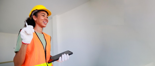 Portrait happy smling black woman Professional black femal engineers and inspectors investigating the neatness of houses under construction in housing projects