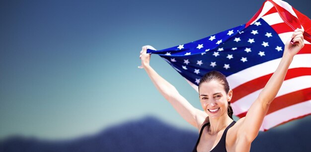 Photo portrait of happy sportswoman raising an american flag