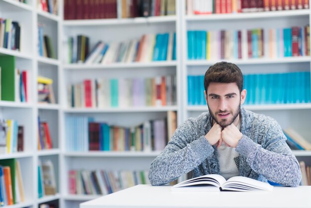 Portrait of happy student while reading book in school library Study lessons for exam Hard worker and persistance concept