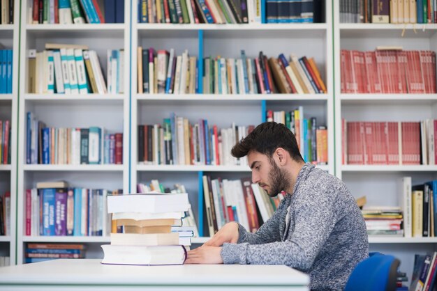 Portrait of happy student while reading book in school library Study lessons for exam Hard worker and persistance concept