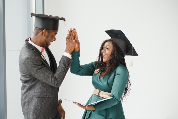 Portrait of happy students holding diplomas on graduation day