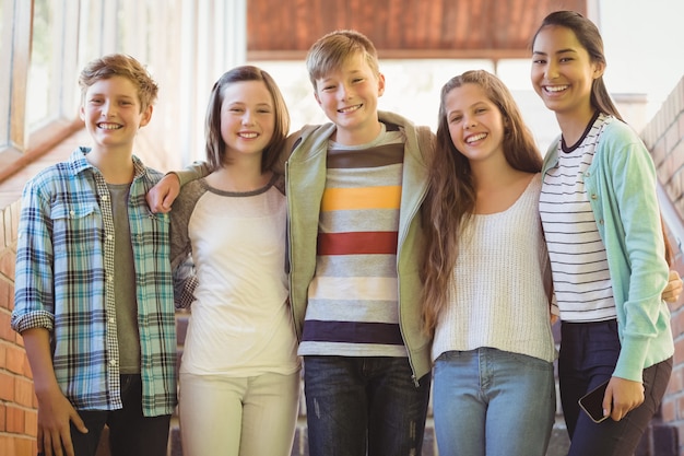 Photo portrait of happy students standing with arms around in corridor