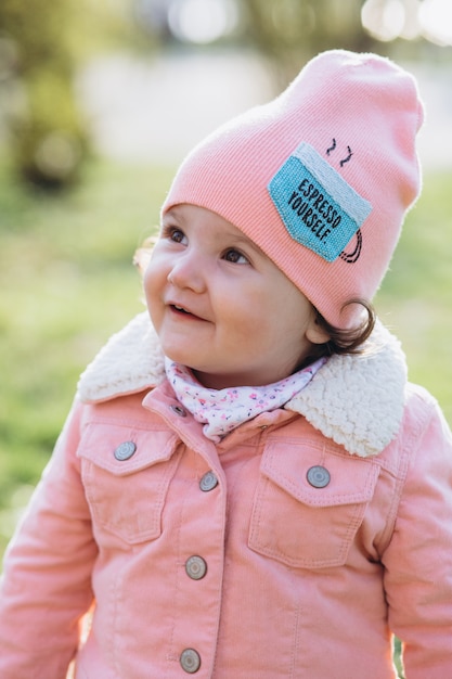 Un ritratto di una felice elegante bambina in una giacca di jeans rosa