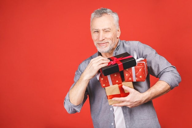 Portrait, happy super excited senior man, opened, unwrapped\
gift boxes, isolated, enjoying his present. positive human emotion,\
facial expression, feeling attitude, reaction.