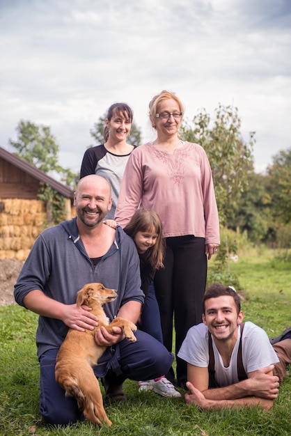 portrait of happy three generations family with dog at beautiful countryside farm
