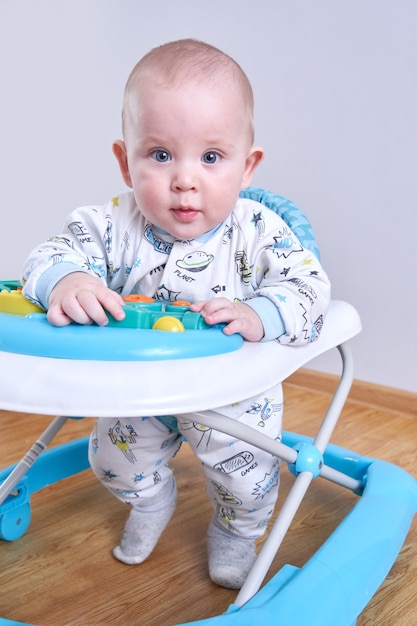 Portrait of happy toddler in baby walker at home