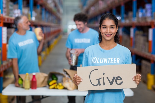 Portrait of happy volunteer holding a sign